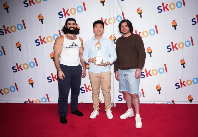 Nate Herk holding a Skool Games award at a Skool community event alongside fellow creators